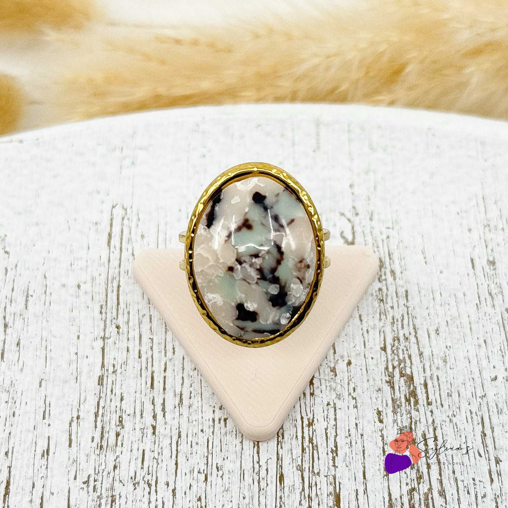 Bague artisanale ovale Clara en argile polymère marbrée, montée sur un anneau en acier doré ajustable, faite main en France.