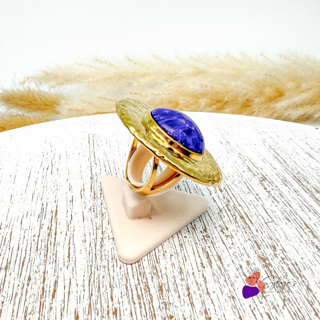 Bague artisanale Jacinthe en argile polymère avec cabochon violet et plateau doré martelé, montée sur support ajustable, bijou unique fait main.