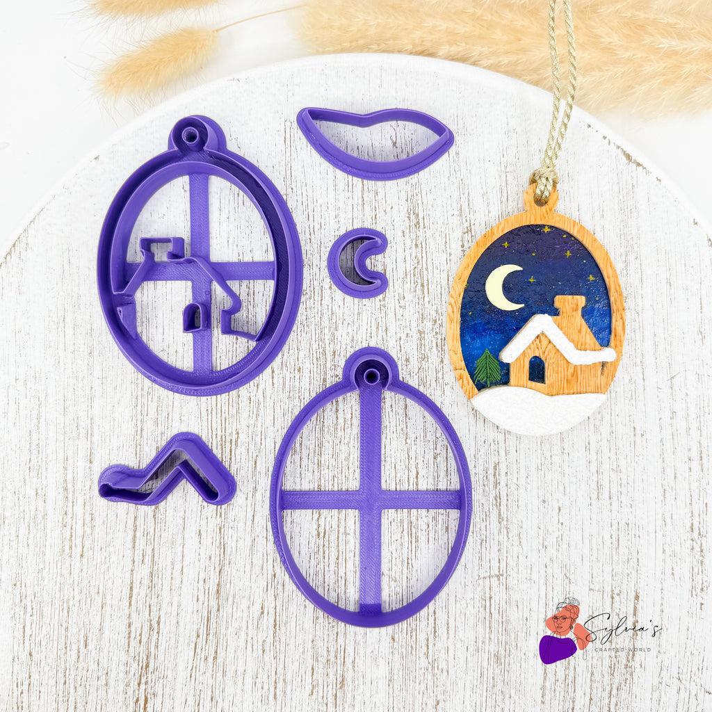 Set d’emporte-pièces en forme de boule de Noël avec maison enneigée pour argile polymère — outils en PLA violet biodégradable pour créations Fimo, Cernit ou Sculpey — exemple de décoration terminée avec ciel étoilé et lune.