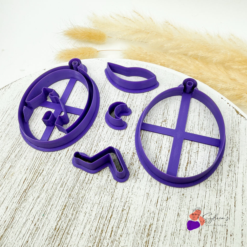 Vue de côté des emporte-pièces pour argile polymère en forme de maison enneigée dans une boule de Noël — accessoires de modelage imprimés en 3D pour créations artisanales festives.