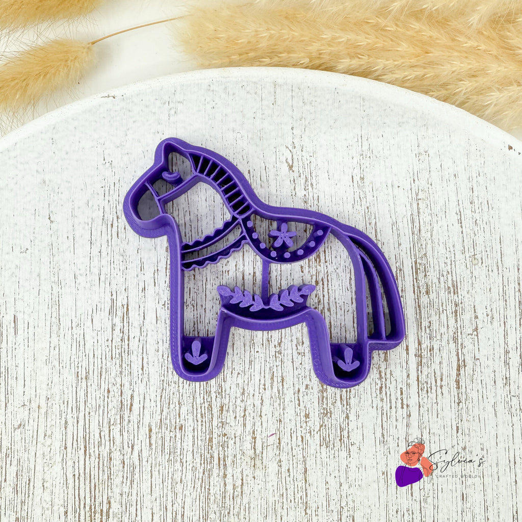 Emporte-pièce cheval de Noël en plastique violet vu de dessus, motif scandinave détaillé pour pâte polymère.