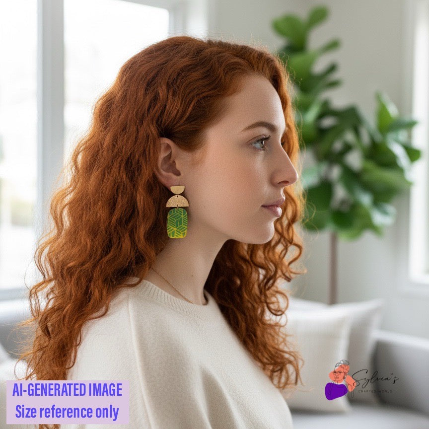 Femme portant des boucles d’oreilles artisanales en argile polymère vertes et jaunes à motifs géométriques et demi-lunes dorées, montrant la taille et le style du bijou – image de référence pour Sylvia’s Crafted World.