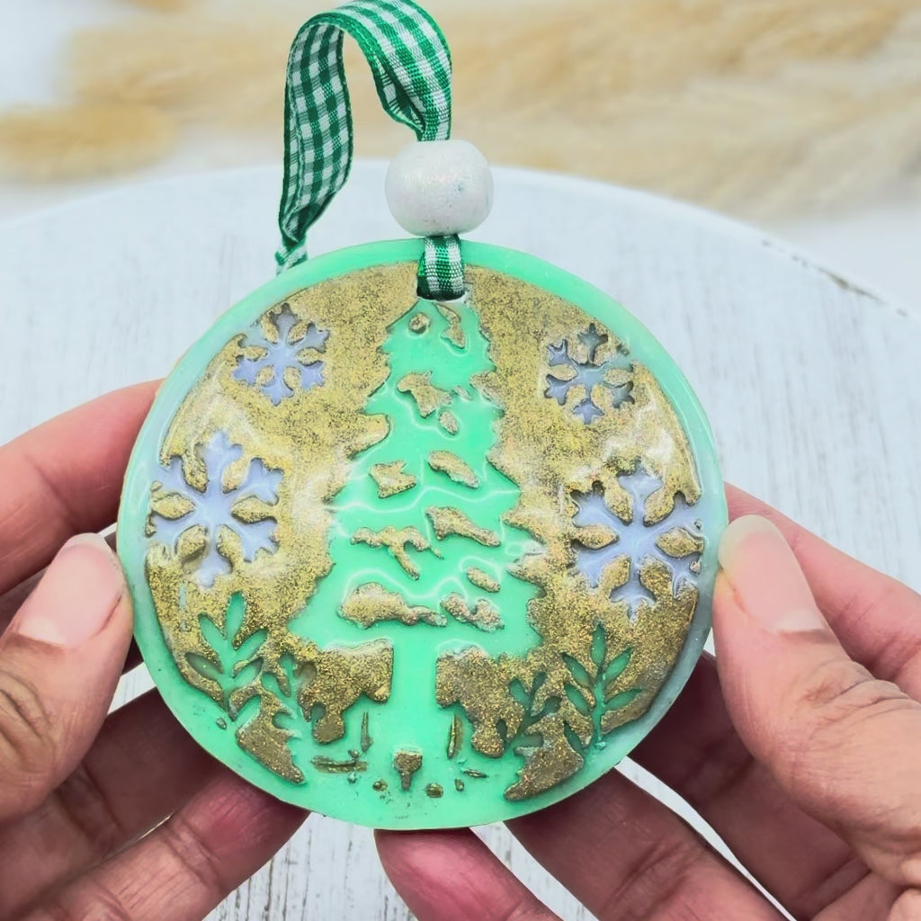 Décoration de Noël en argile polymère verte avec motif sapin et flocons dorés réalisée avec le set d'emporte-pièce et texture pour boule de Noël.