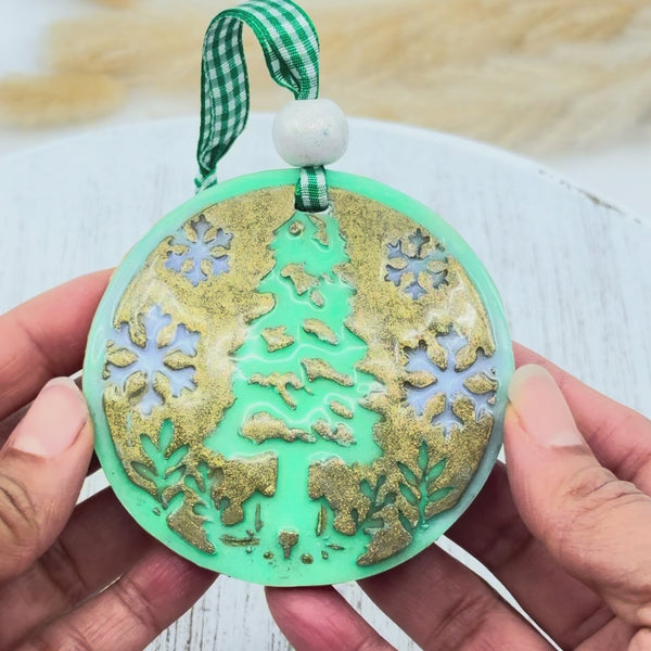Décoration de Noël en argile polymère verte avec motif sapin et flocons dorés réalisée avec le set d'emporte-pièce et texture pour boule de Noël.