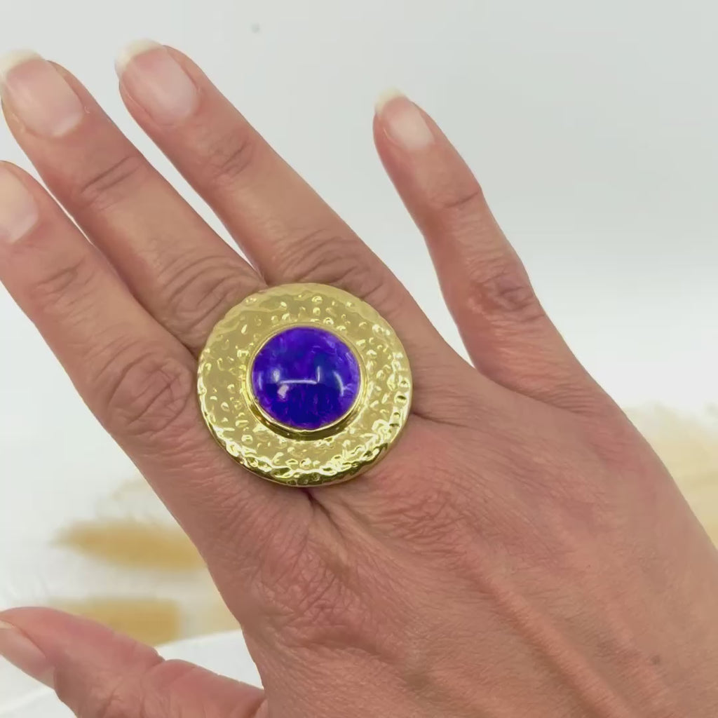 Bague artisanale Jacinthe en argile polymère avec plateau doré martelé et cabochon violet, portée sur une main. Bijou unique fait main en France.