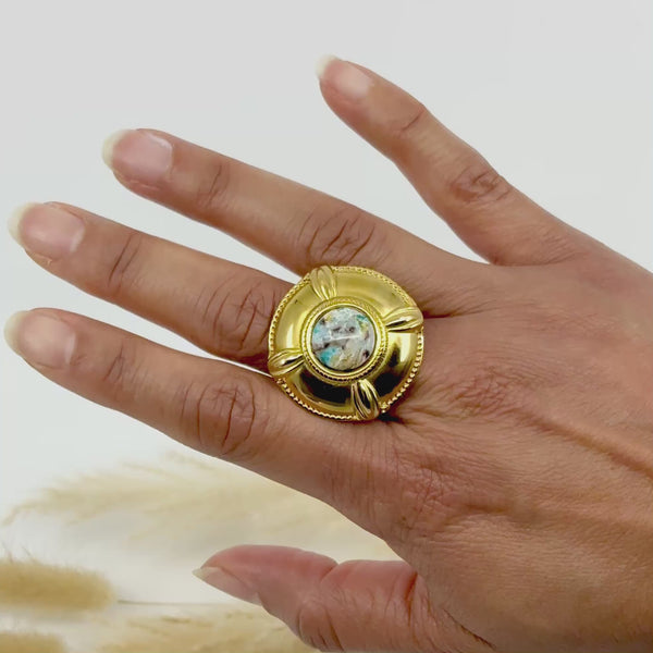 Bague dorée artisanale en argile polymère "Diane" portée sur une main, avec motif central texturé inspiré de la nature. Bijou unique fait main en France.